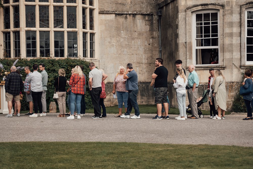 Guests queue for sustainable cocktails at wild wedding venue in gloucestershire
