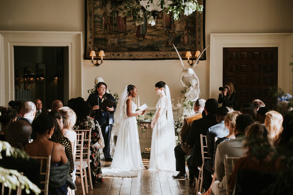 Two brides read vows to eachother in touching same sex wedding ceremony in historic wedding venue hall