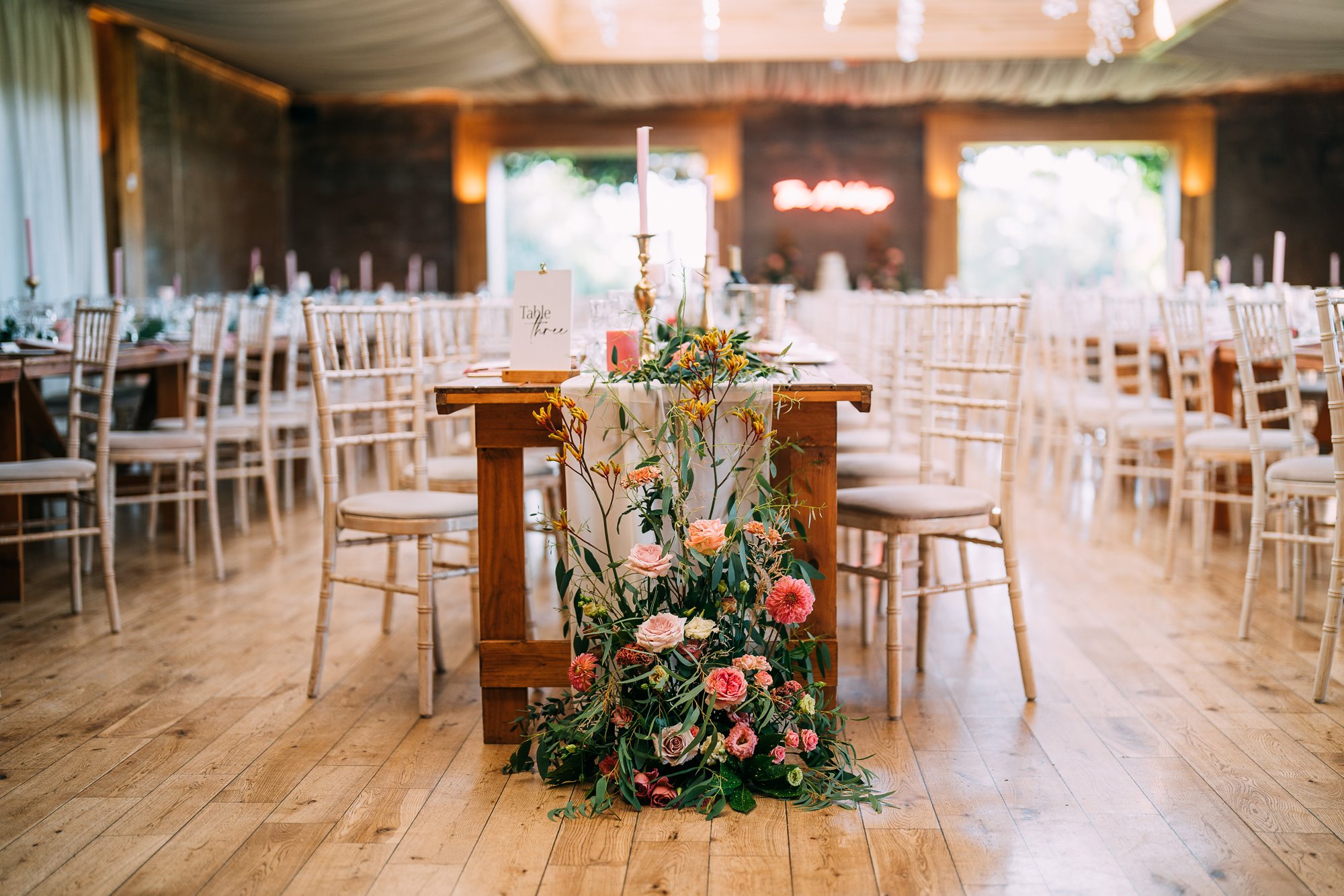 flower displays at the ends of long tables at a wedding reception party