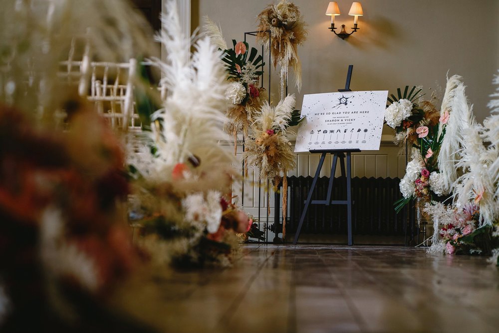 Beautiful pampas grass and printed ceremony details for a lesbian wedding ceremony in a stately home