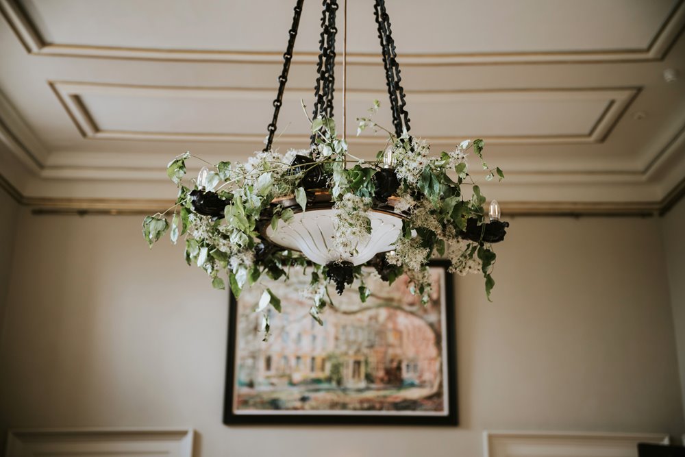 flowers hanging from a light feature at a wedding ceremony at Elmore Court