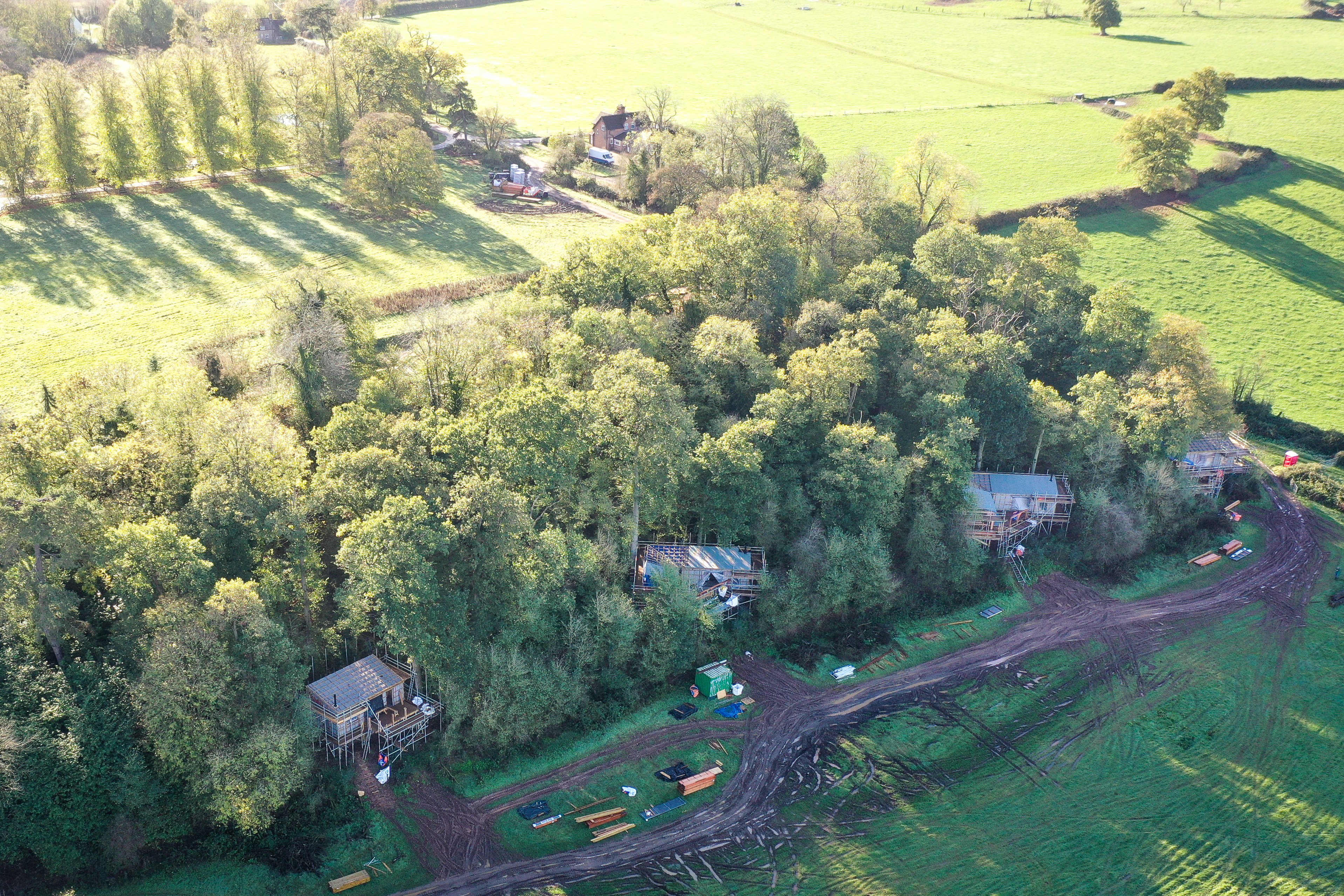 Aerial view of treehouses being built in woodland on the elmore court estate overlooking their rewilding project in the UK