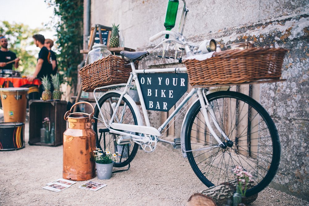 Bike gin bar with sign saying on your bike for a festival style garden wedding