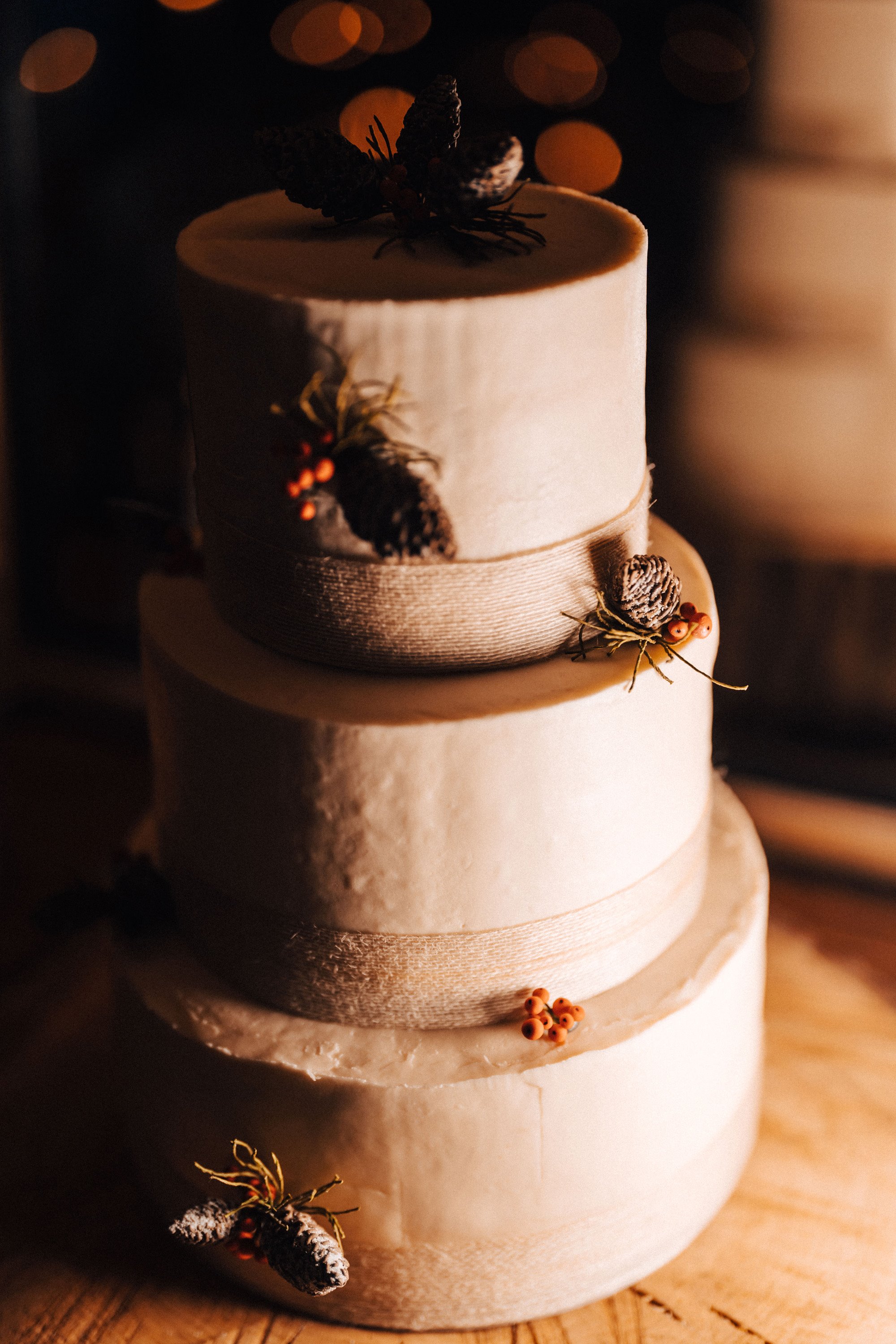 Christmas wedding cake with red ribbon and pinecones