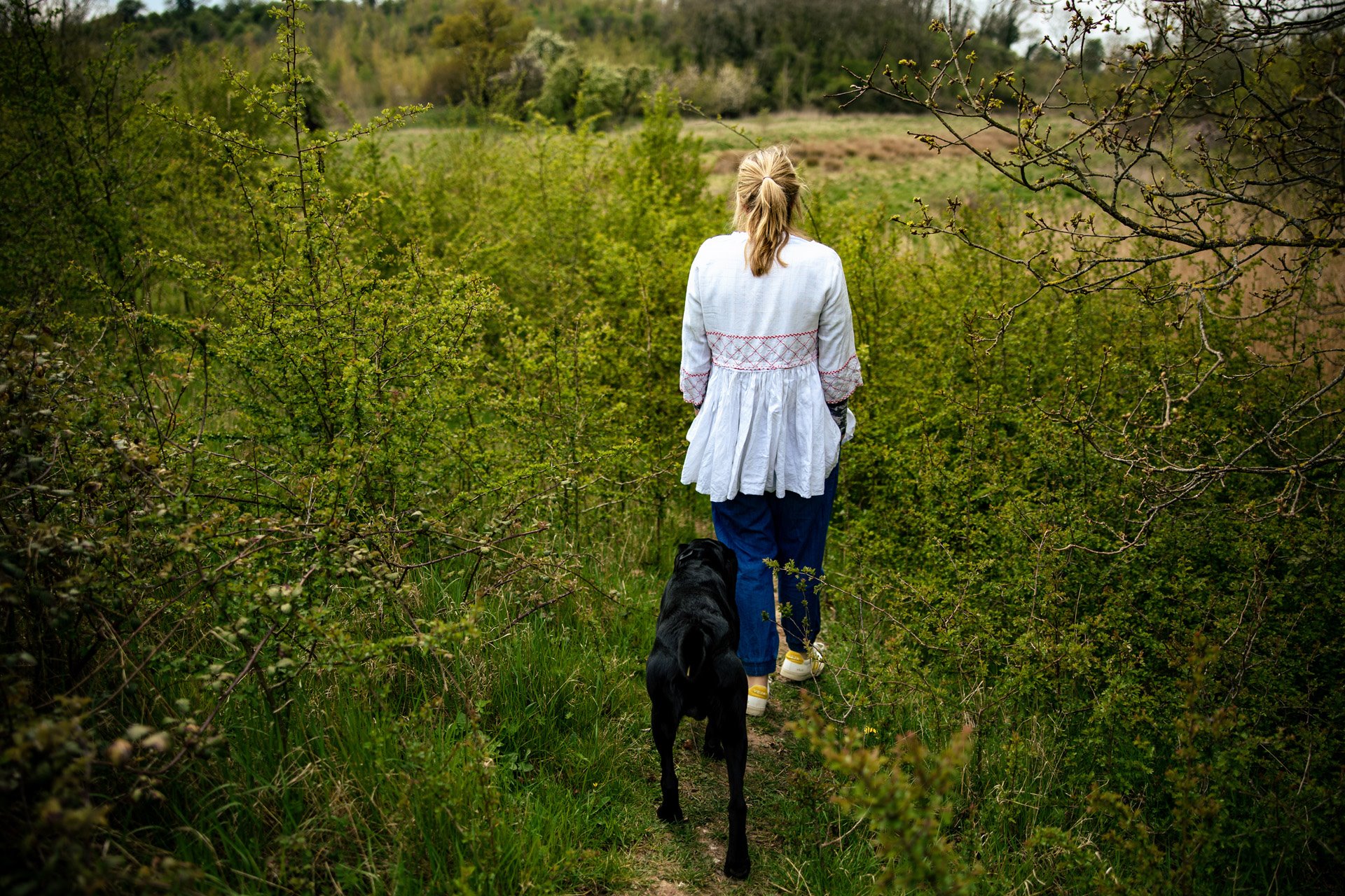 Rewilding project owner walking her dog through the ever changing wild wedding venue land