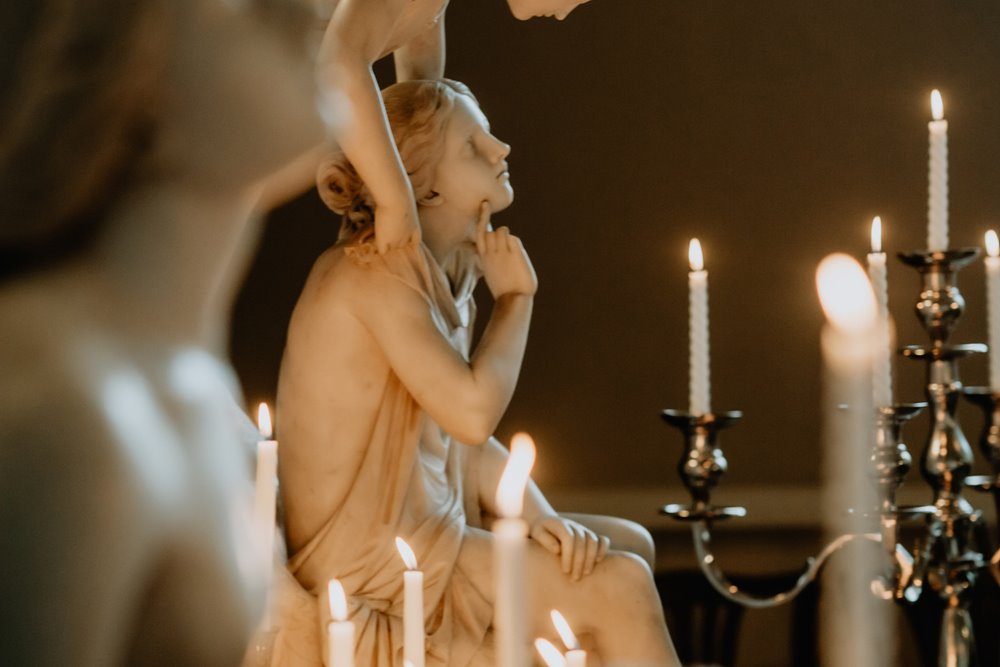 dark and moody wedding inspiration at candlelit wedding ceremony with huge angel statues