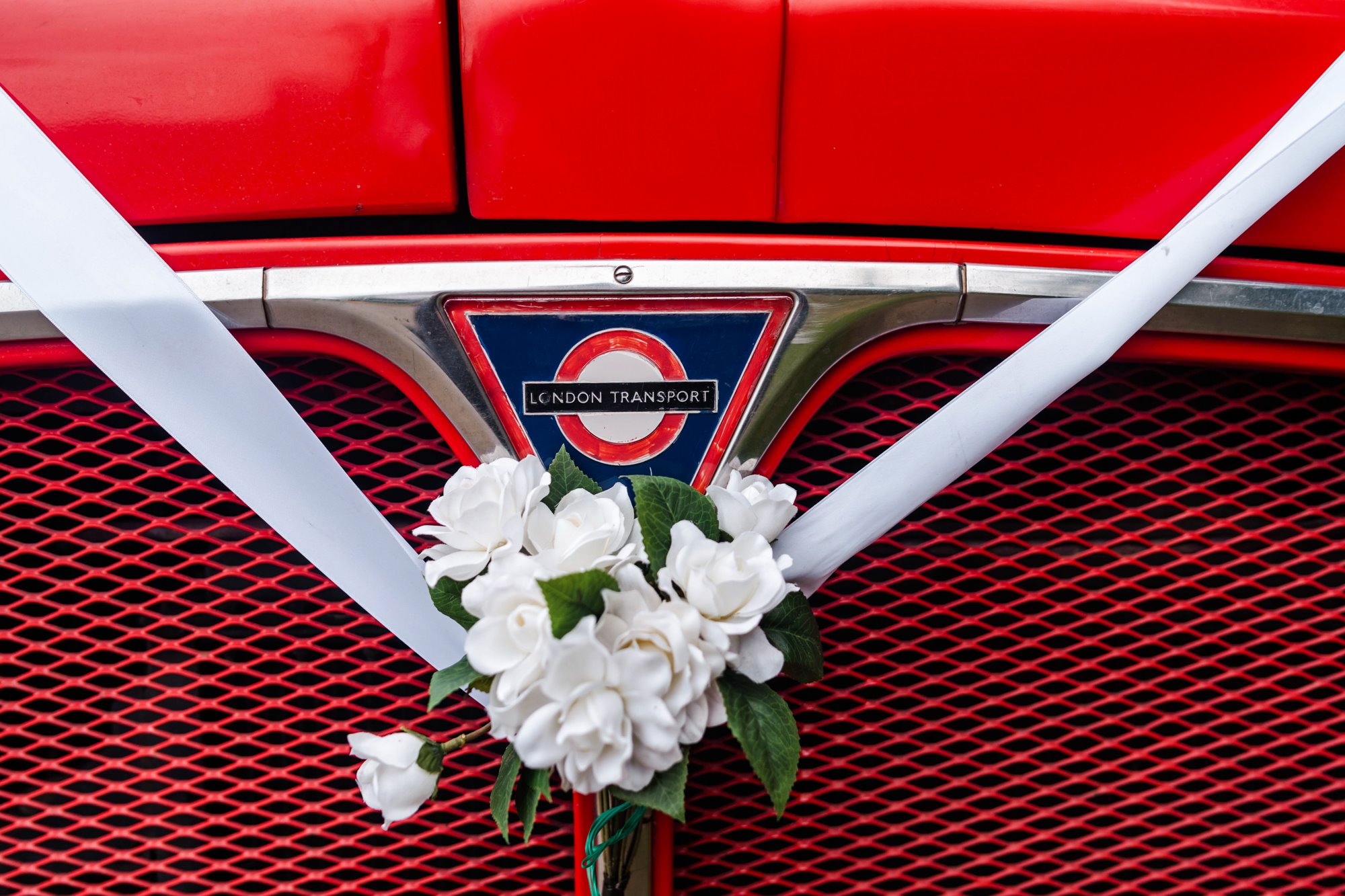 vintage London bus decorated with a flower and ribbon for tea party garden style wedding