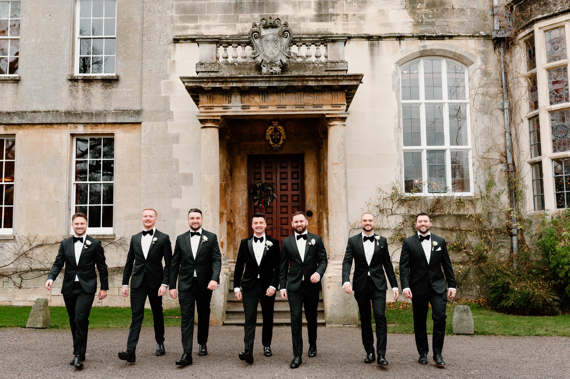 groom and his groomsman lined up outside a stately home in Gloucestershire 