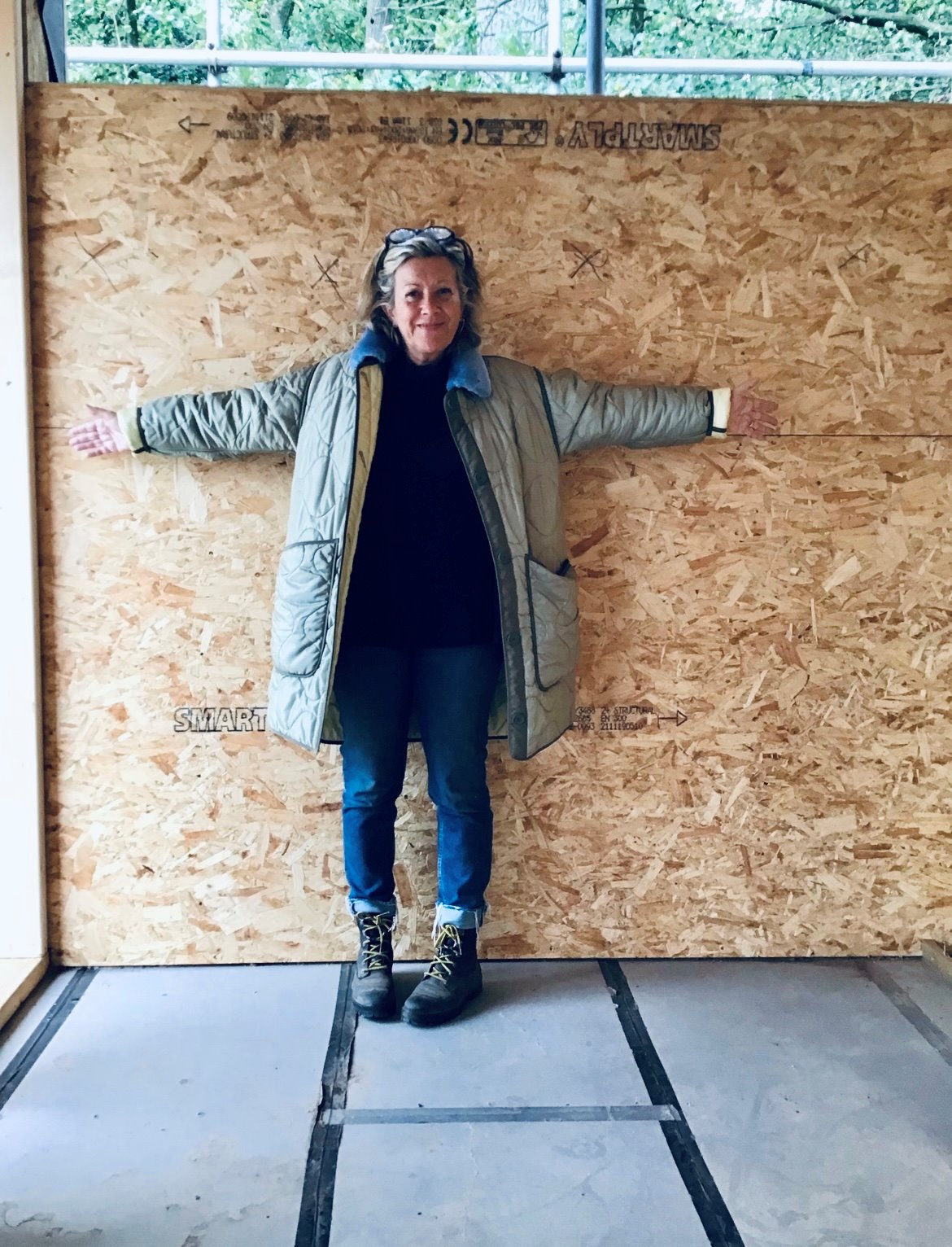 Interior designer Tracey Boyd standing in the middle of a treehouse construction project at Elmore Court