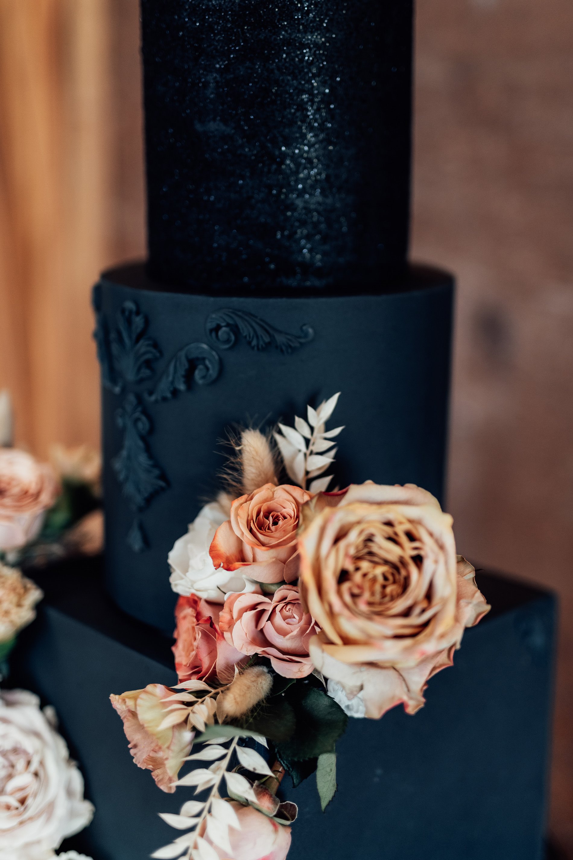 Black wedding cake with sparkles and real flowers