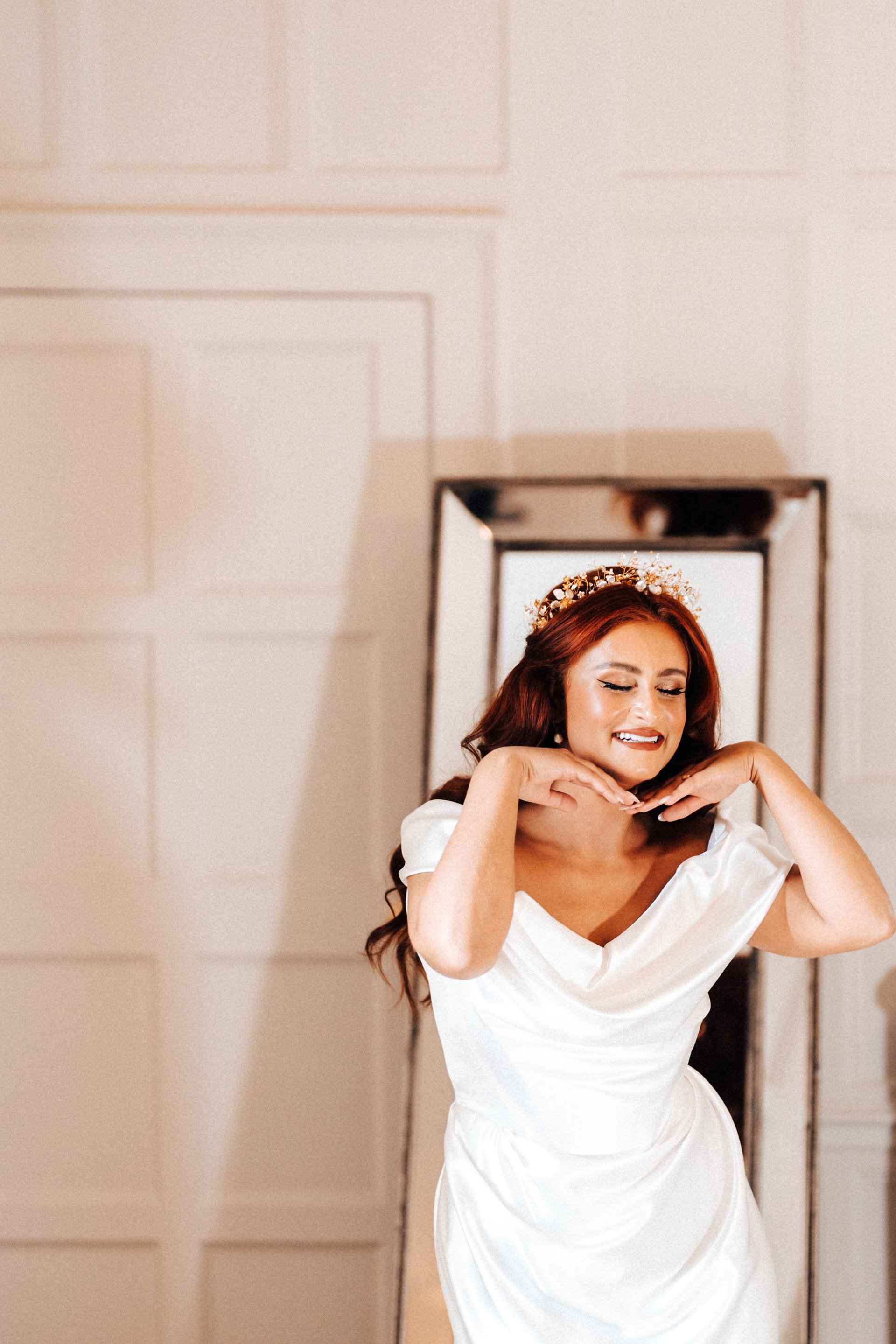 Beautiful bride with red hair poses in her Vivienne Westwood gown at her September wedding