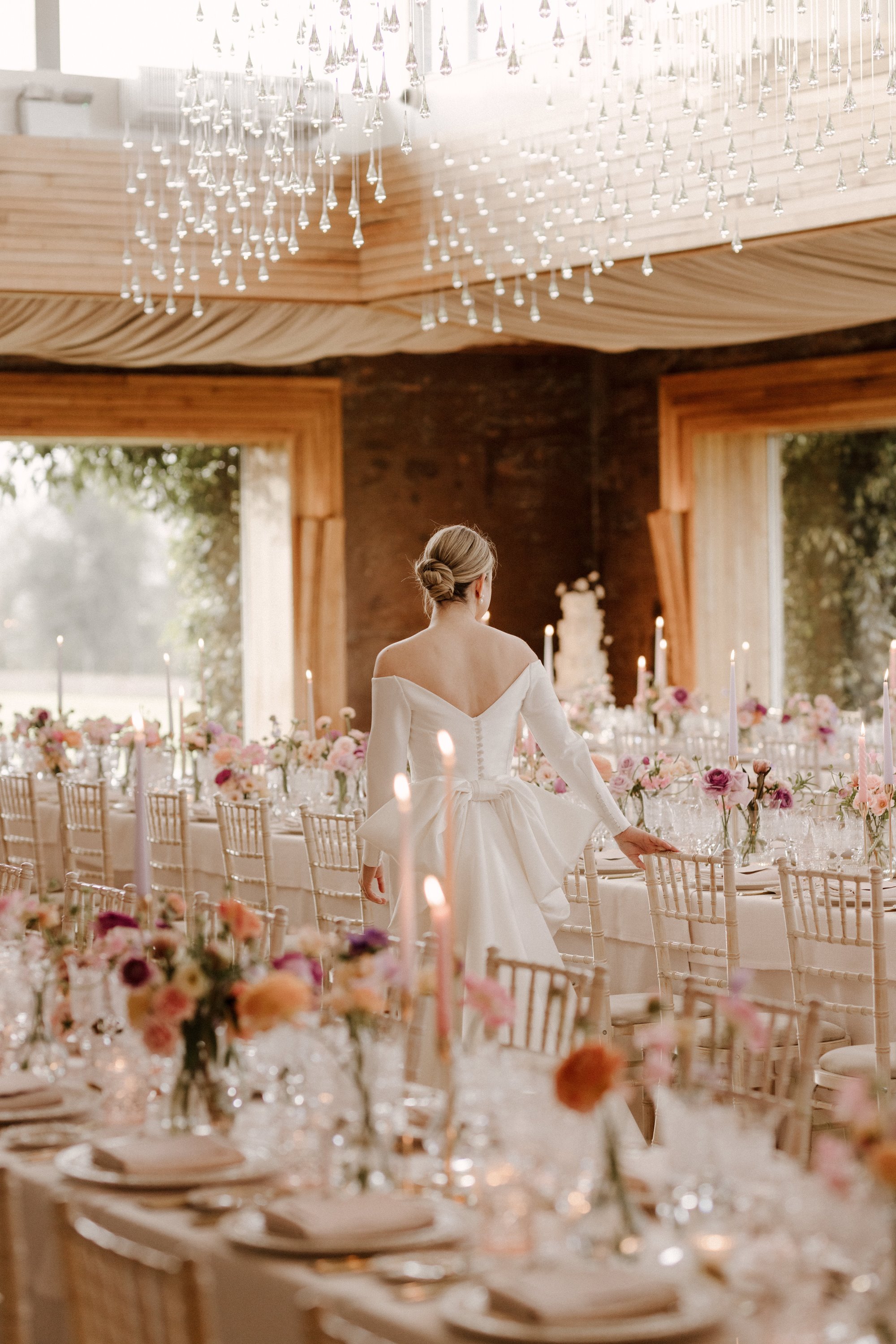 a stunning bride admiring the beautifully staled tables at her wedding reception at Elmore Court