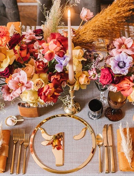 Beautiful colourful tablescape with rose gold cutlery for a cool luxe festival wedding at elmore court in the cotswolds