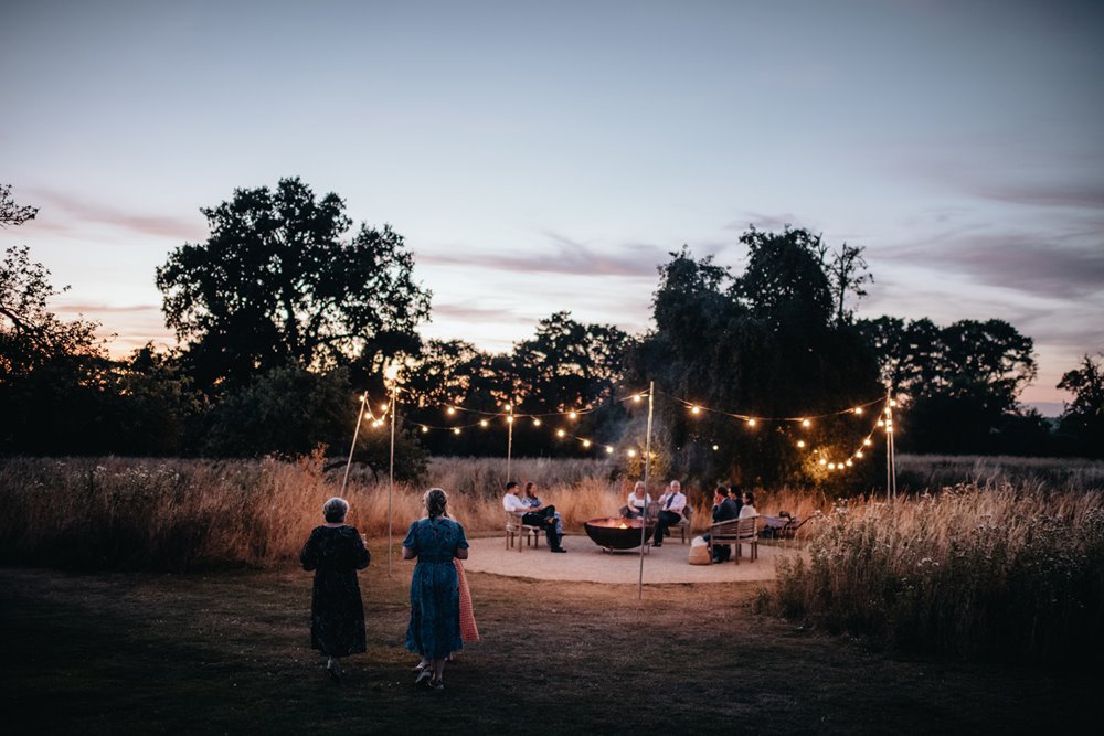 cool outdoor wedding next to a fire pit at sunset