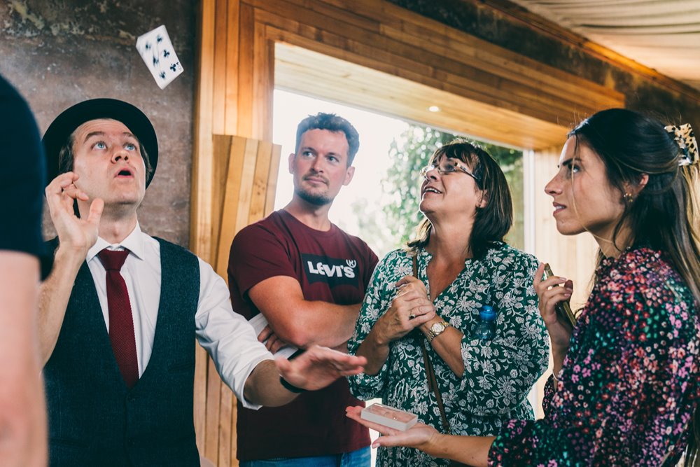 Wedding magician Darren Campbell showing off his tricks to amazed guests at wedding fair at elmore court