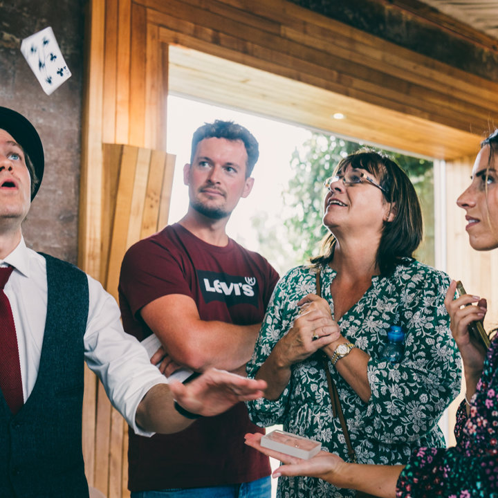 Wedding magician Darren Campbell showing off his tricks to amazed guests at wedding fair at elmore court