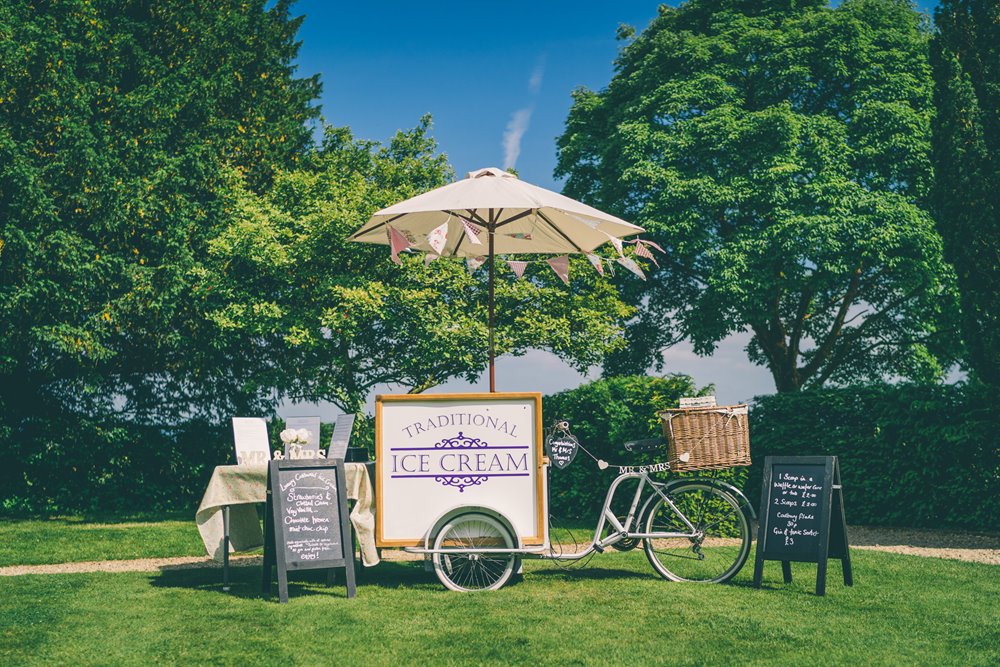 Cotswolds ice cream stand with parasol and bunting for a vintage garden tea party wedding outdoors