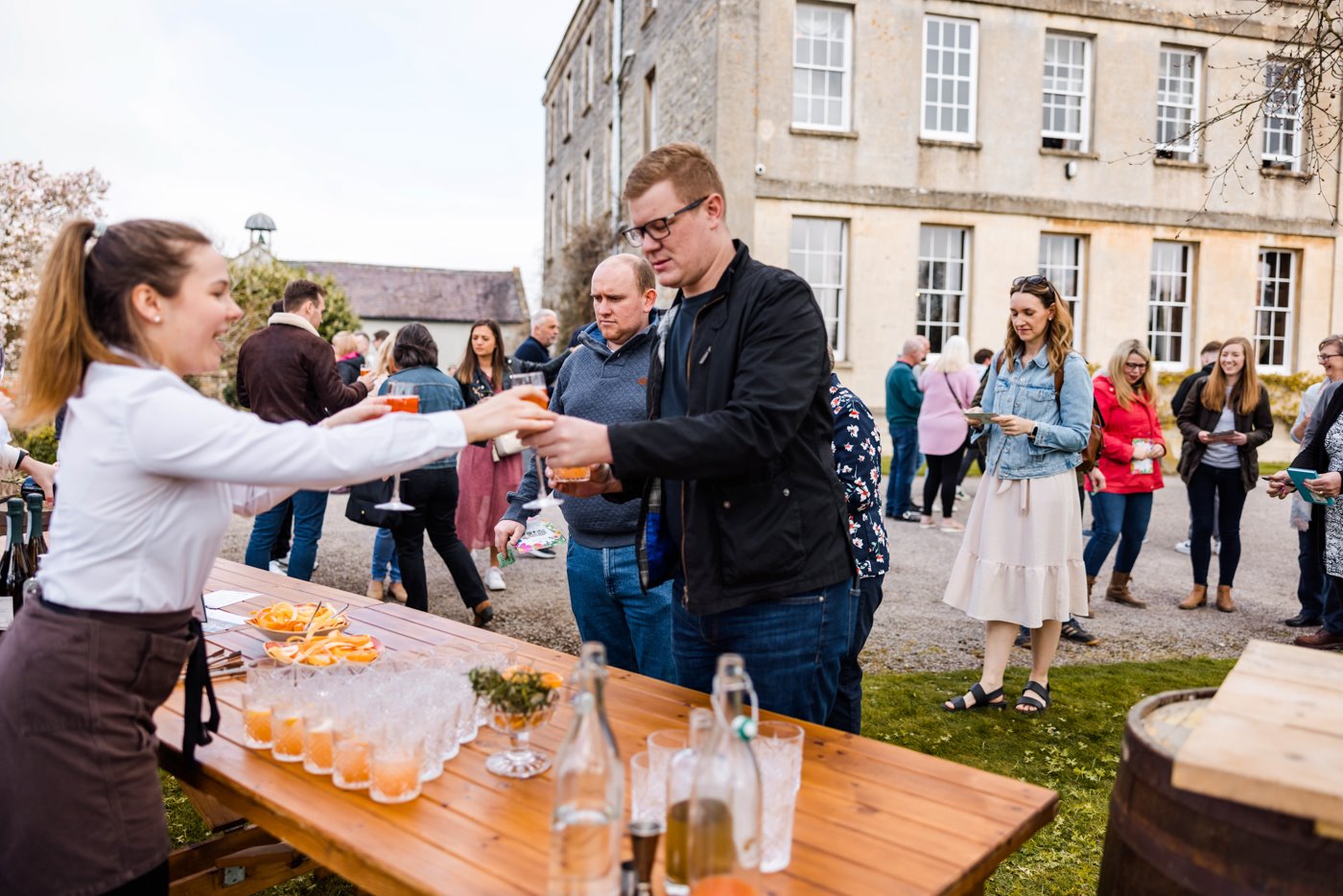 Team E hand out cocktails to guests as they arrive at wild wedding fair with festival feel in gloucestershire