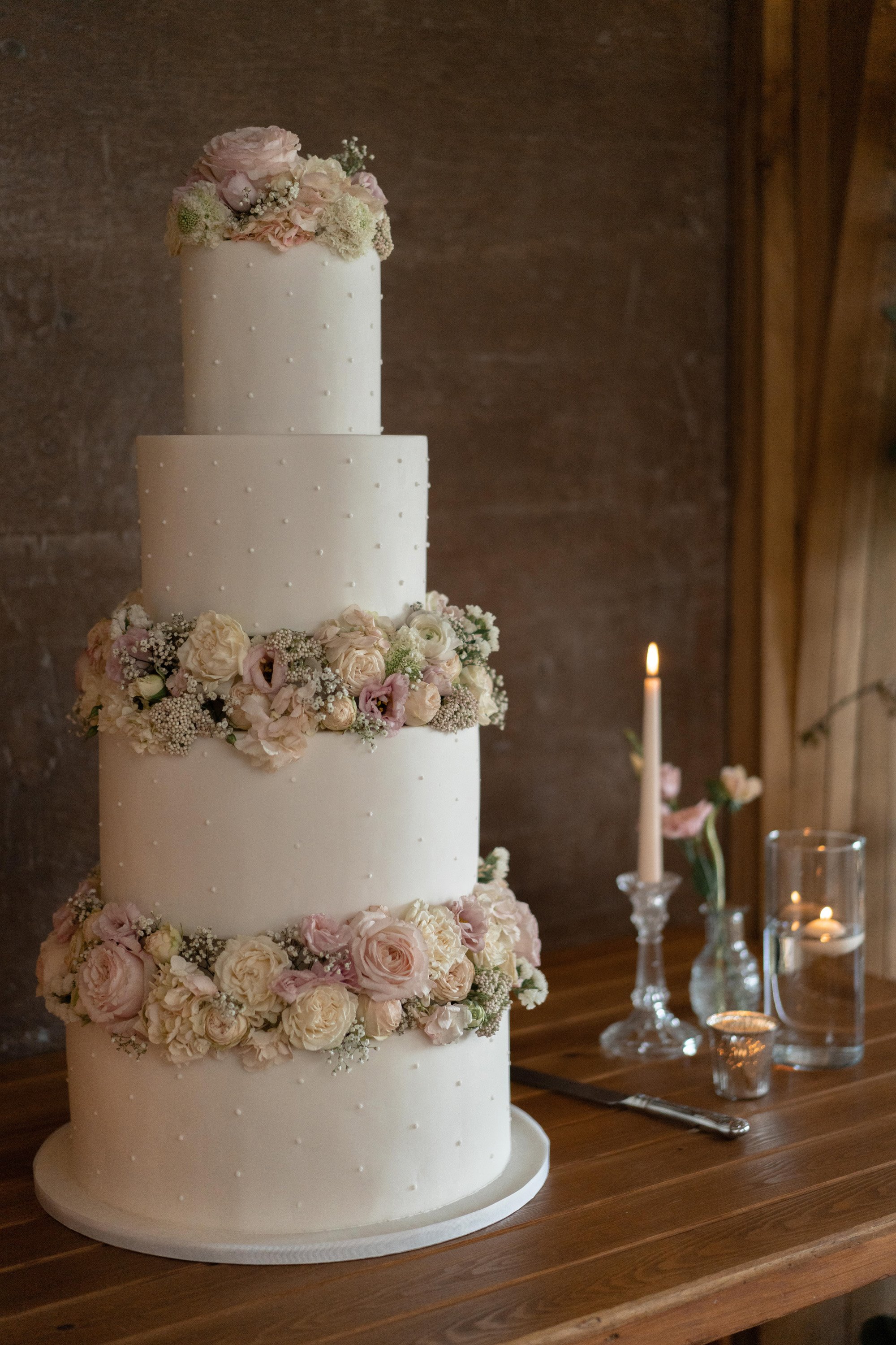 Pearl wedding cake with three tiers decorated with real roses and tiny pearls
