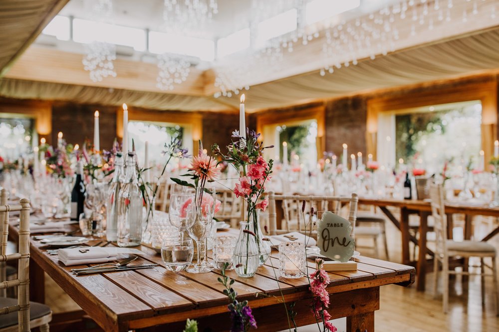 Pretty pink flowers and decor at an eco wedding reception venue in the cotswolds