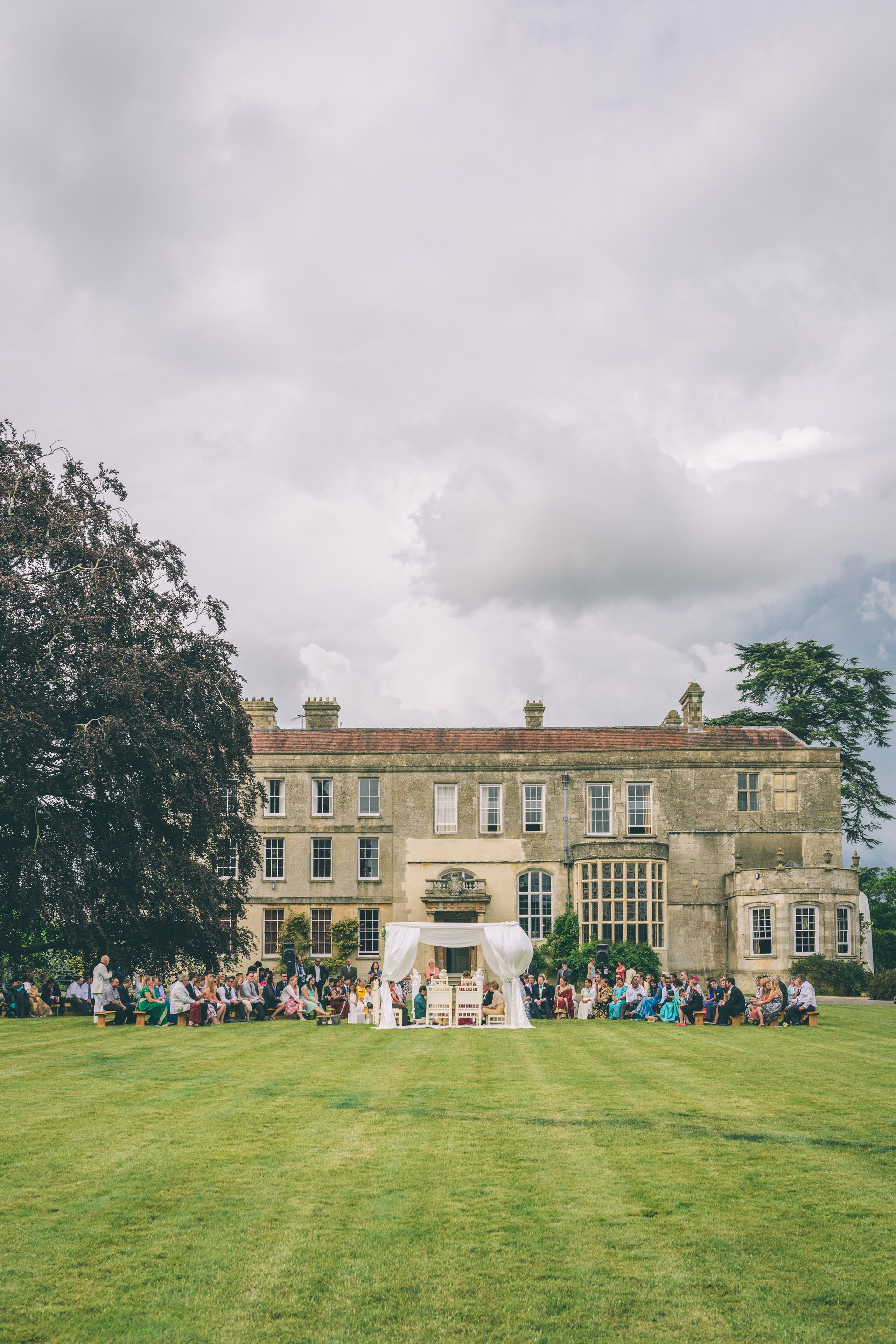 Indian Outdoor wedding ceremony in a white mandap on the lawn in front of the house