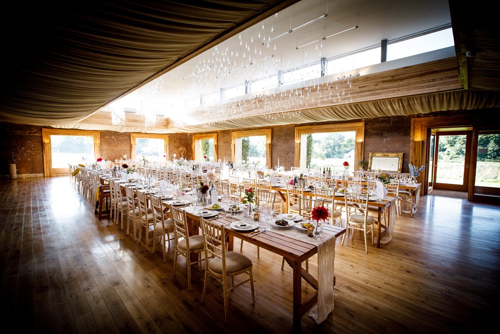 Beautifully decorated Long wooden tables for a gay wedding reception at elmore court