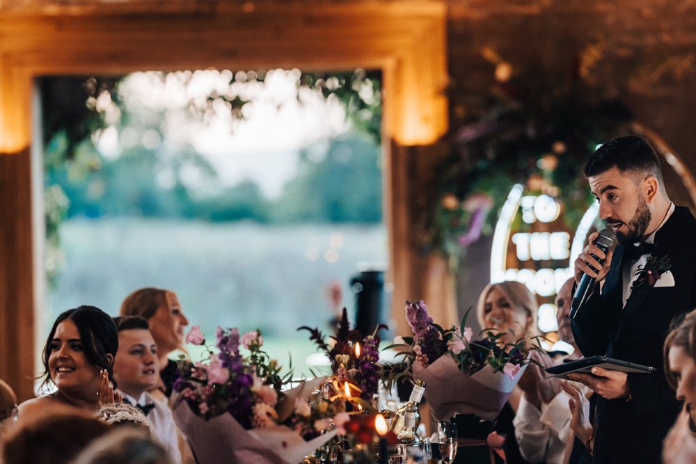 Grooms speech at a magical autumn wedding in October with black flowers, cake and candles and celestial decor