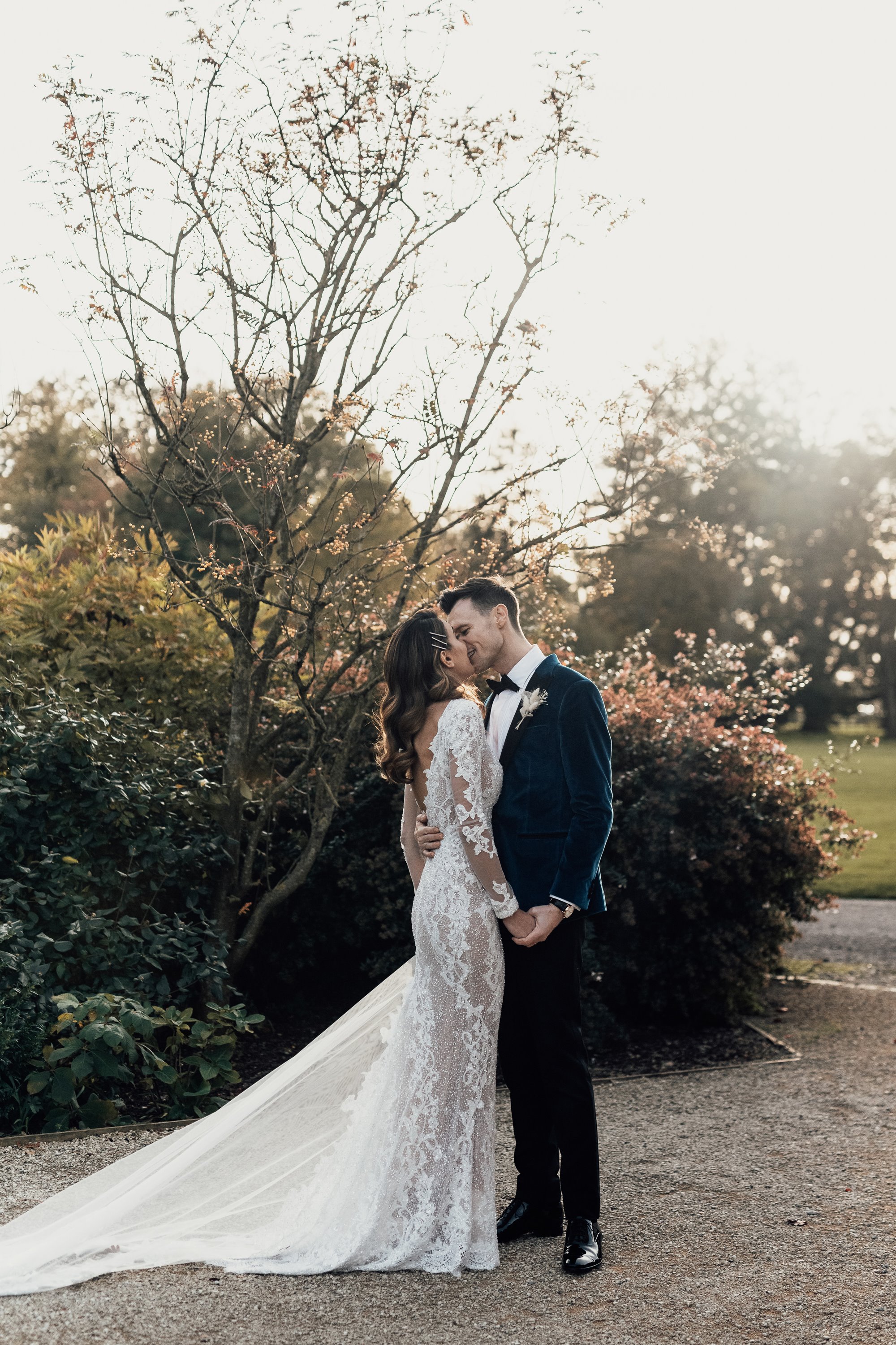 bride wearing a beautiful laced wedding dress embracing her husband at a Gloucestershire wedding venue