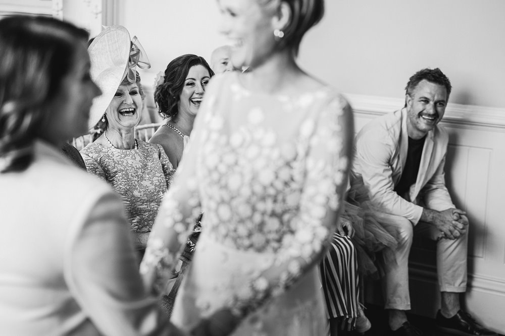 lesbian wedding ceremony brides hold hands and smile