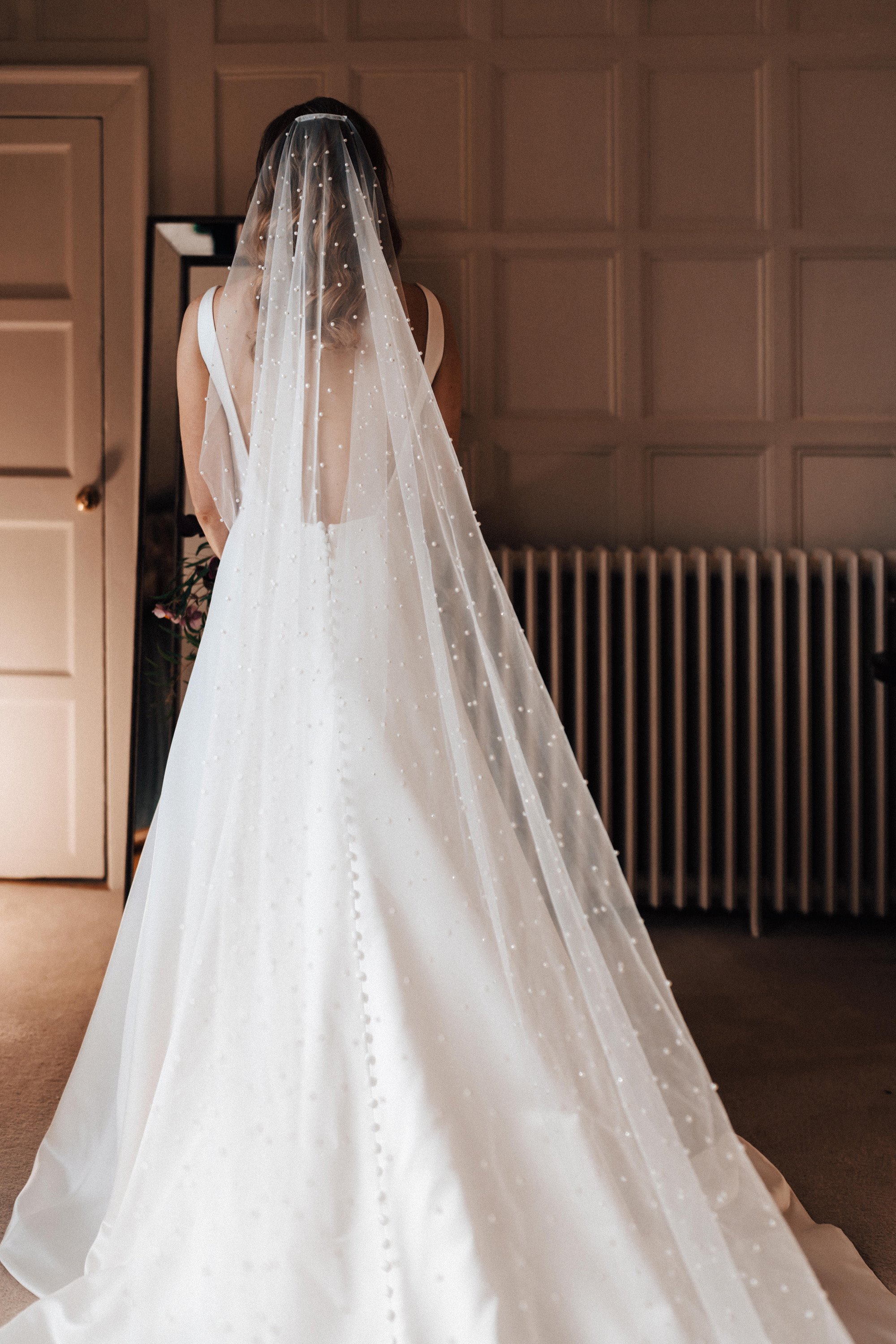 Bride in full length cathedral veil with pearls for a romantic autumn wedding with dark vibes in october