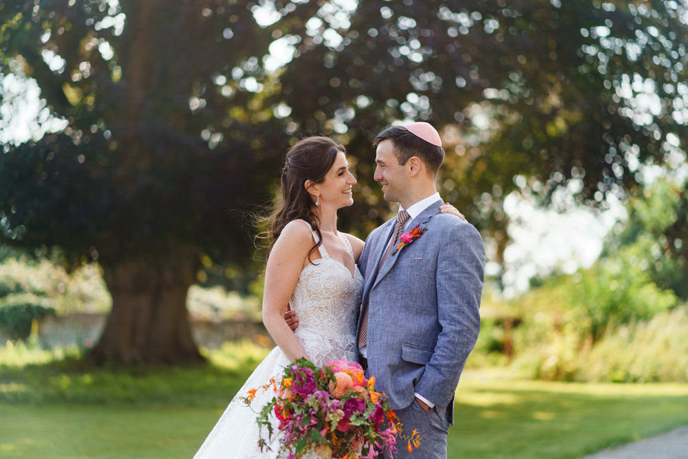 Jewish bride and groom smiling hugging