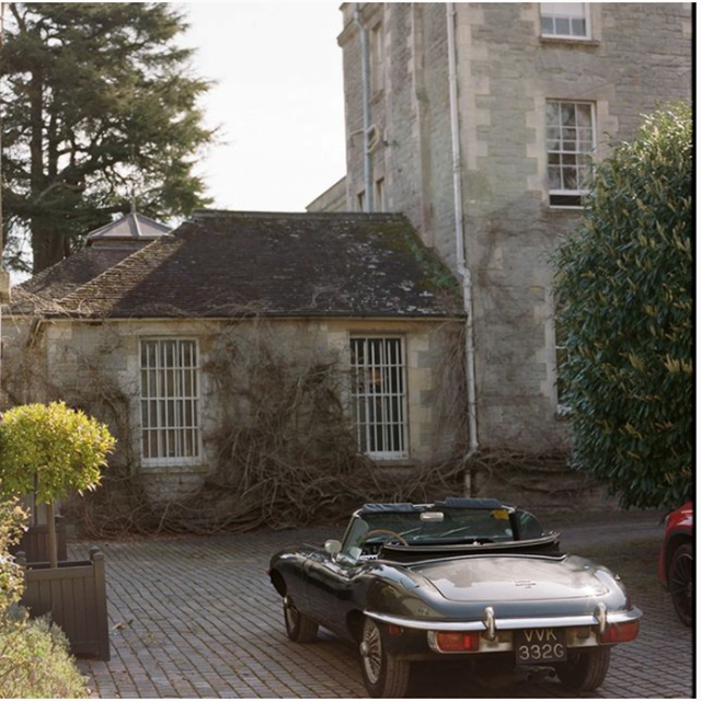 Manor house with classic car parked outside in the cotswolds
