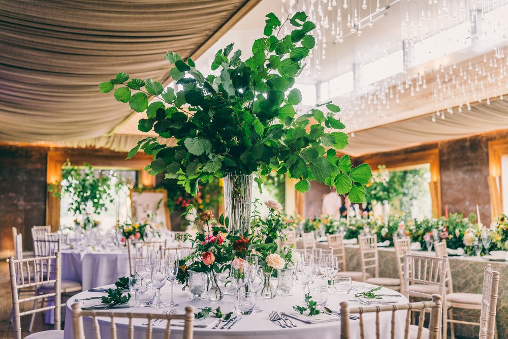Wild wedding florals and greenery decorating party wedding reception venue in the cotswolds