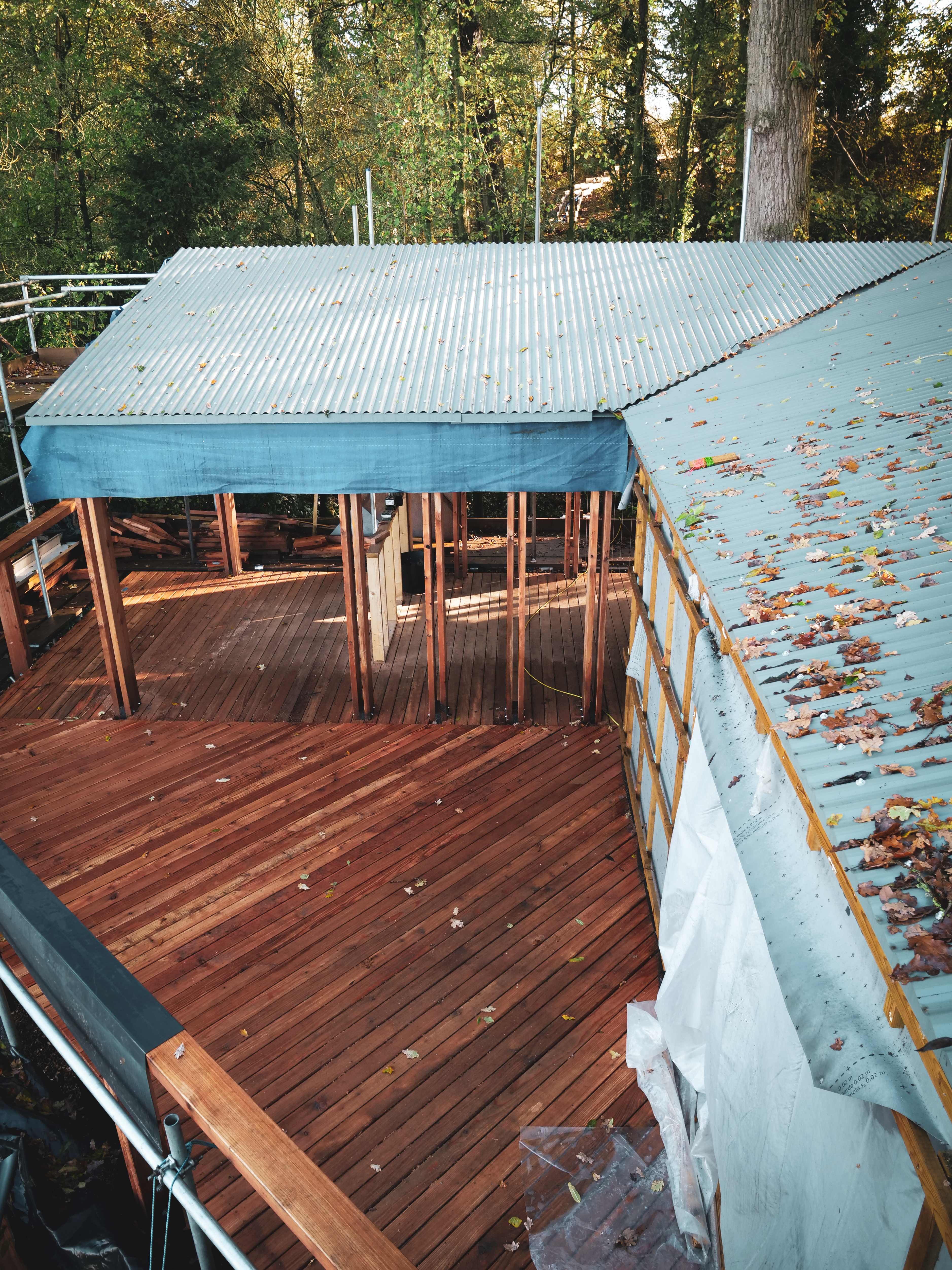View from the roof of a woodland treehouse, looking down onto an outdoor decked area
