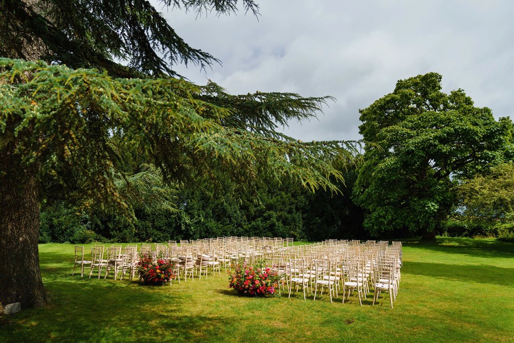 outdoor wedding ceremony next to a magnificenttree on the lawn in summer