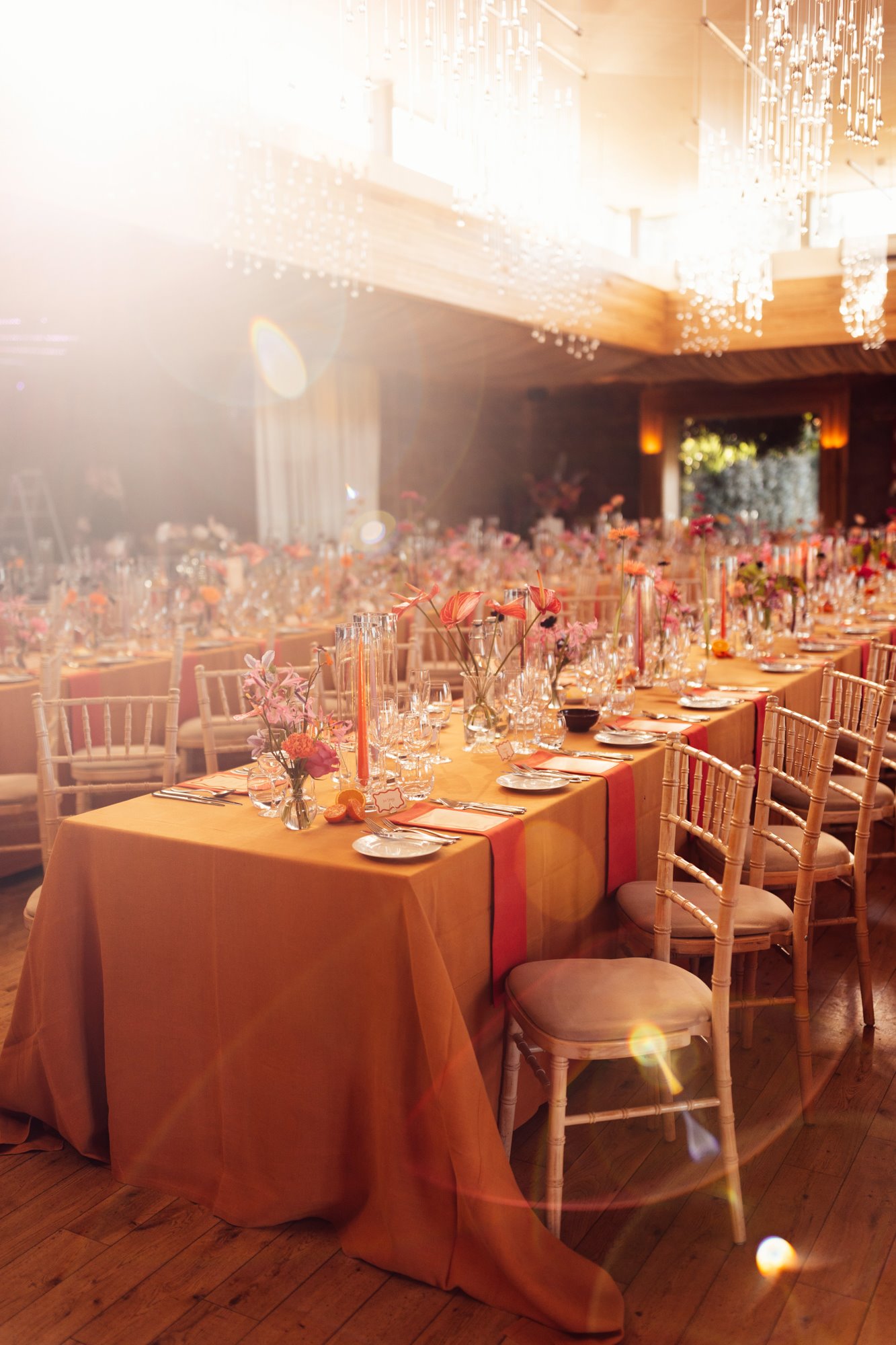 colourful wedding reception with orange tables and bright flowers
