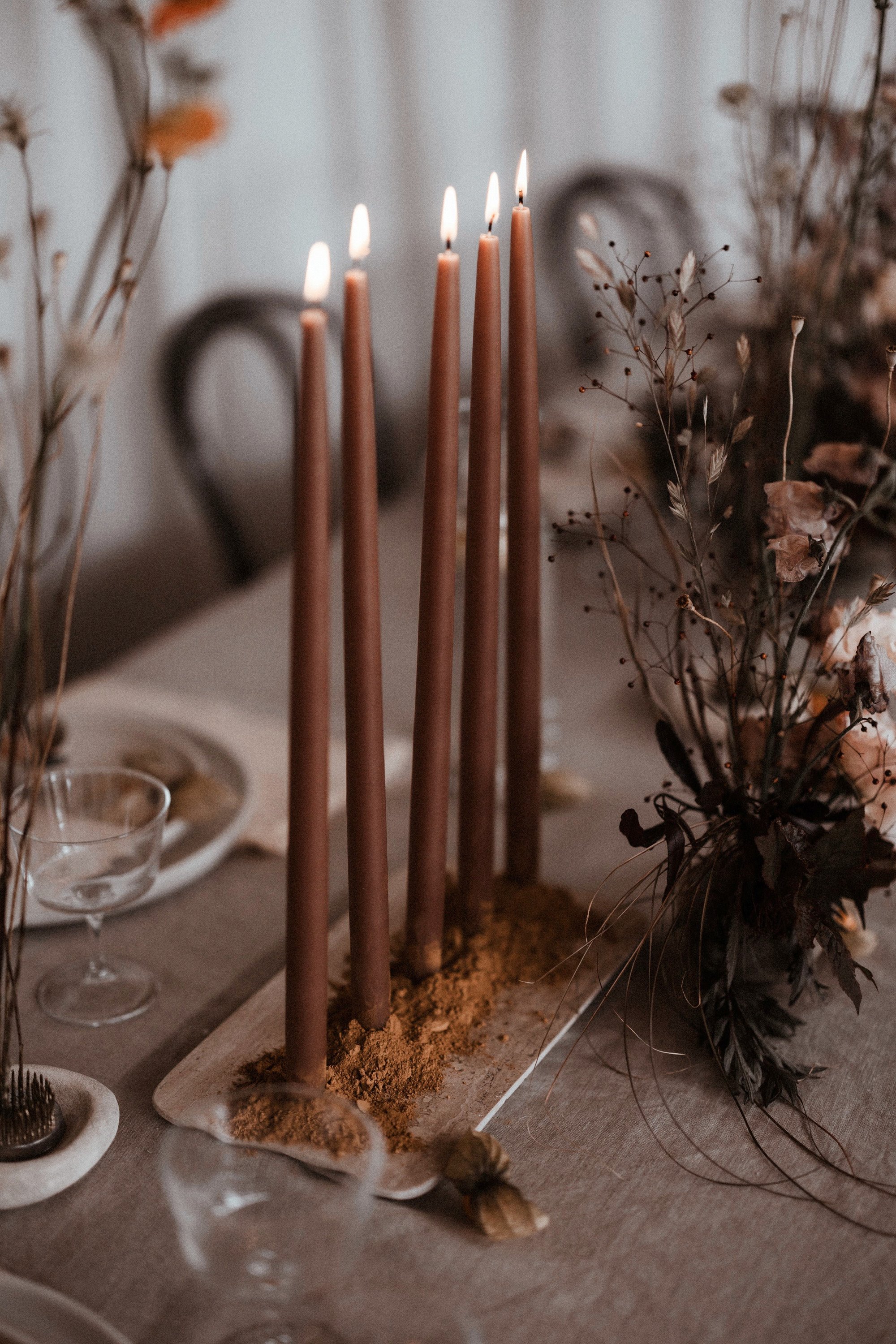 Boho luxe wedding reception tables with real candles and natural details inspired by rewilding