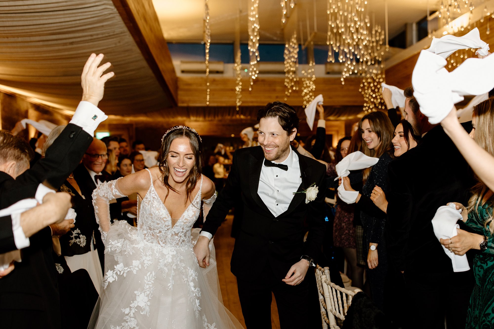 Bride and groom entering their reception party at Elmore Court with all their friends and family cheering