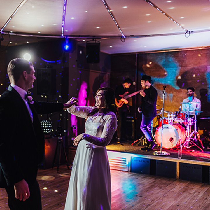 First dance couple laugh in front of amazing wedding band at elmore court soundproof late night party venue
