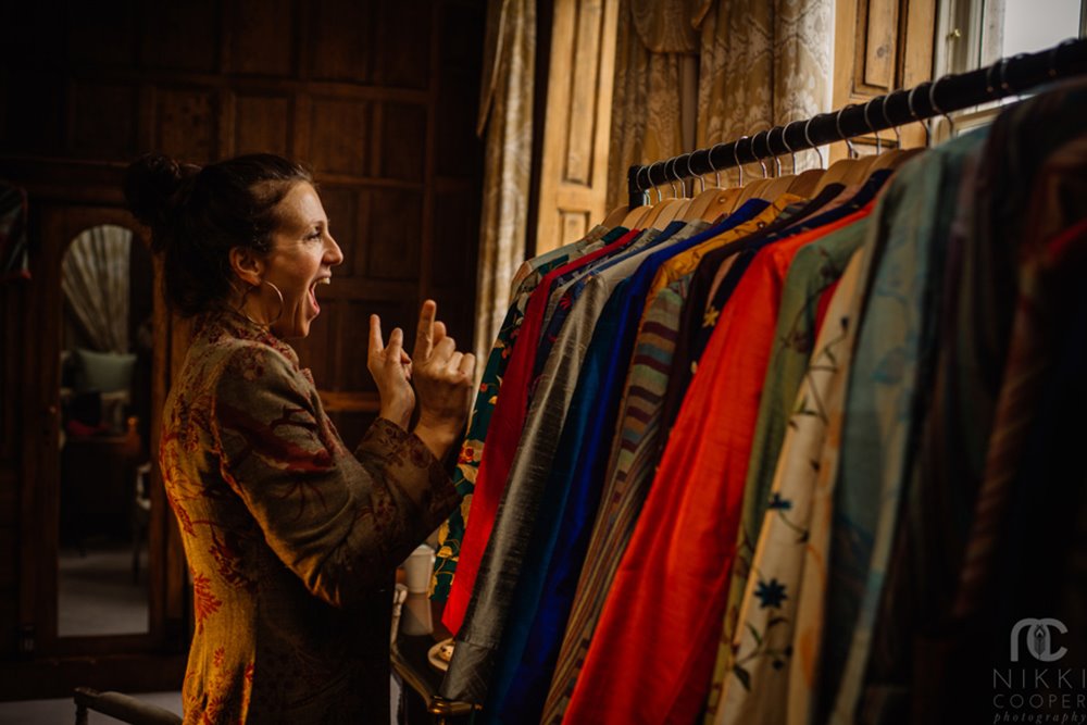 Shibumi founder Ruth excitedly holds fingers up to a rail of cashmere jackets at a wedding fair in Gloucestershire