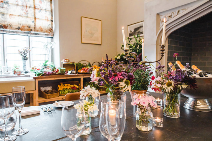 Candlelit dinner set up for a wedding tasting at Elmore Court with fresh flowers and bottles of champagne