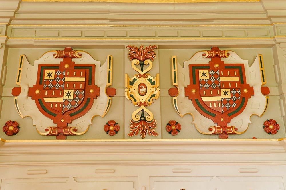 Historic house elmore court Guise family shield is painted above the fireplace in the drawing room