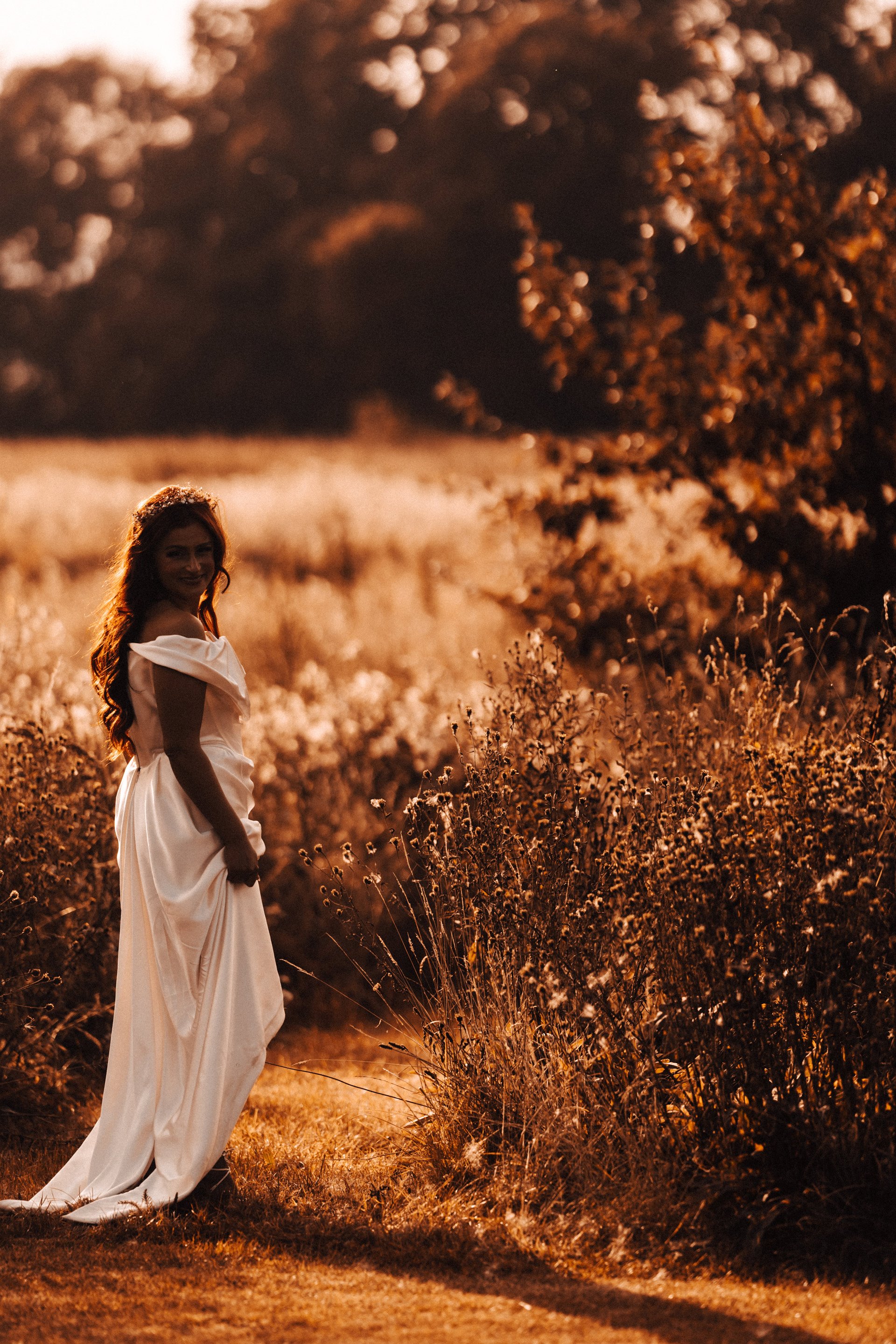 Glowing golden hour bride walking the fields in September sunshine