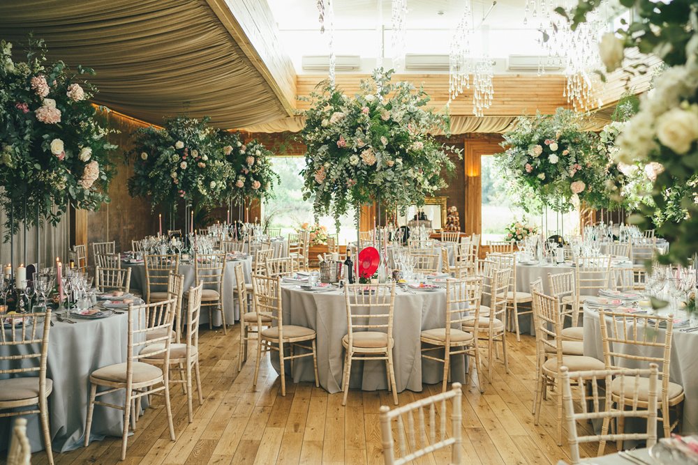 Tall Foliage centre pieces on round tables at a September wedding at elmore court