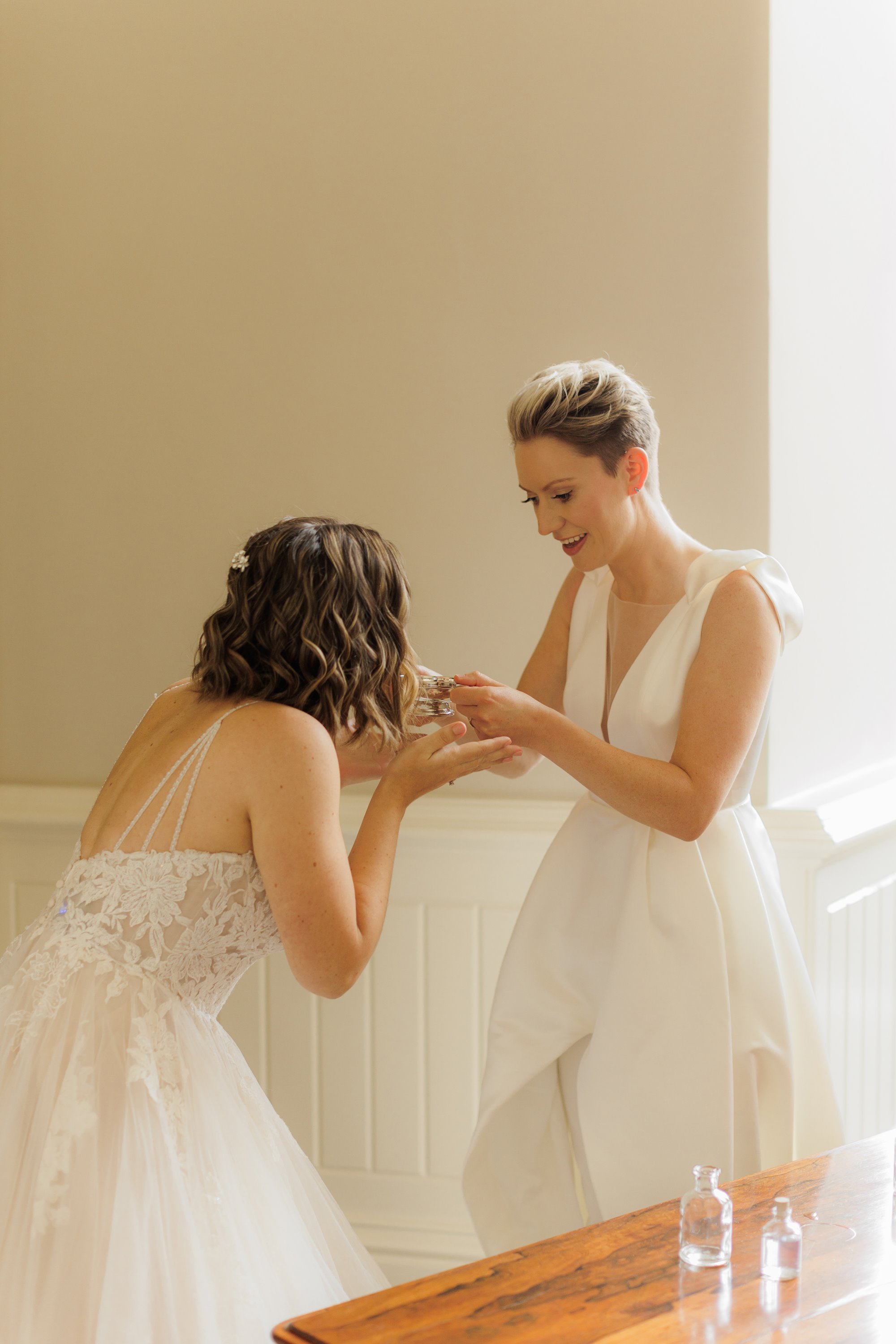 two beautiful brides dressed in white sharing a special moment