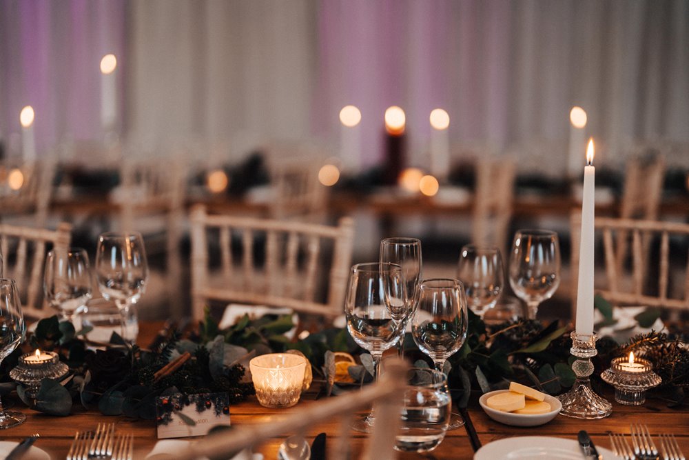 christmas wedding decor and candles on tables at winter wedding reception venue in the cotswolds