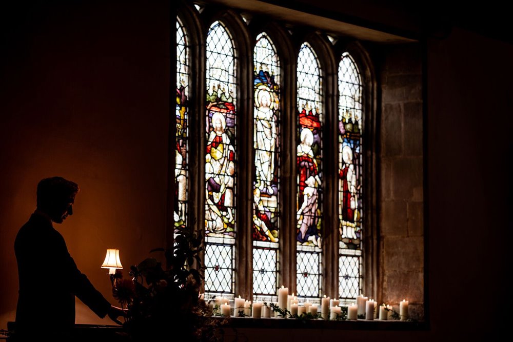 Candlelit church wedding with stained glass looking beautiful in elmore gloucester uk