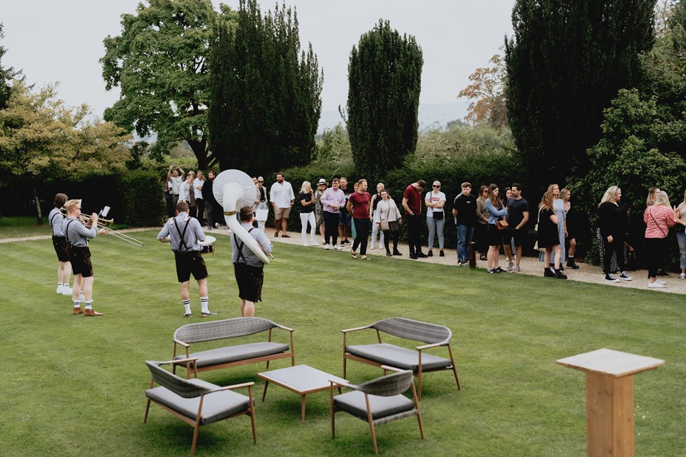 Queue of guests arriving for fun wedding fair with festival bands and cocktails at wedding venue elmore court in Gloucester