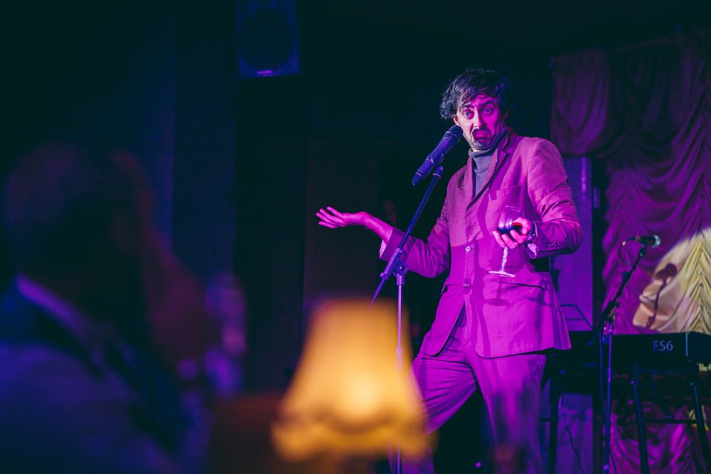 Marcel Lucount stand up comedy in purple at The Parrot Cage cabaret dinner night at elmore court 2020