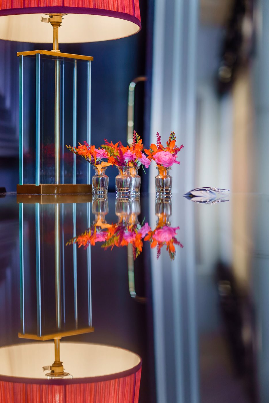 Pretty hot pink buttonholes reflected on mirror table at elmore court